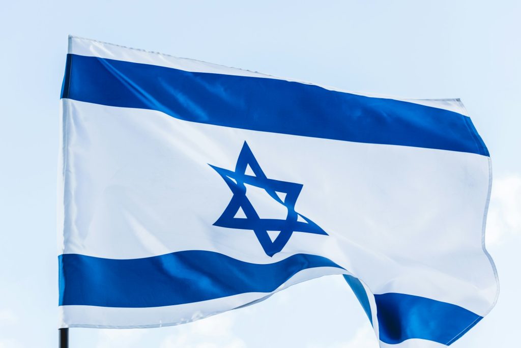 national flag of israel with star of david against sky