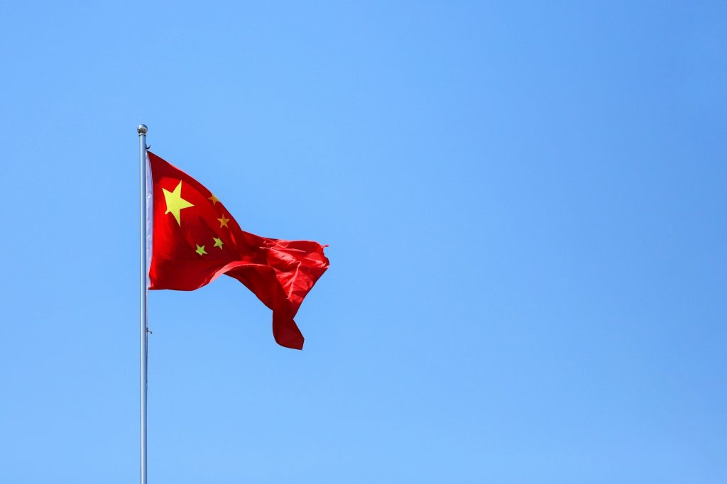 Chinese flag waving against clear blue sky